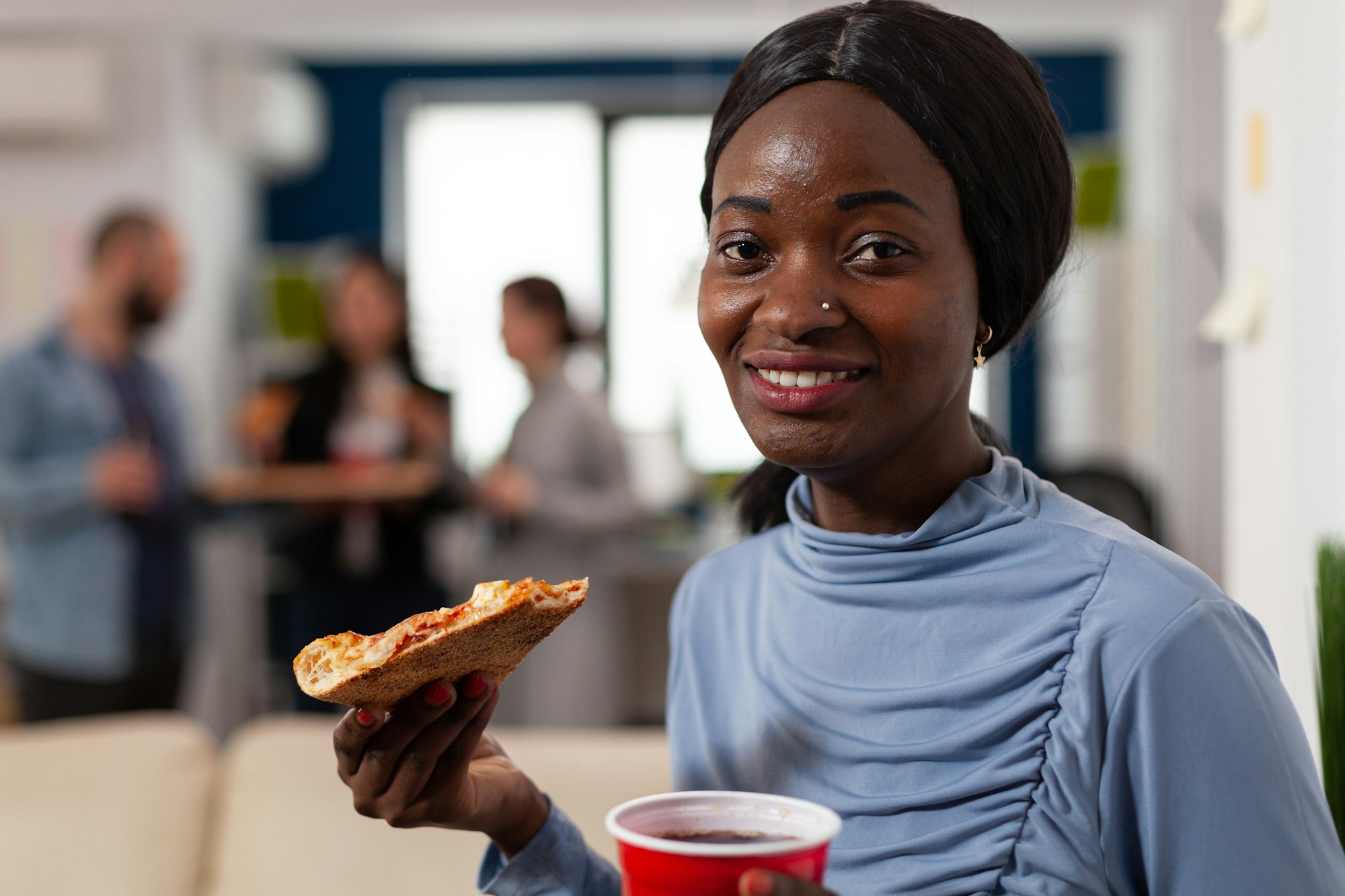 Portrait of african american woman holding pizza and beer