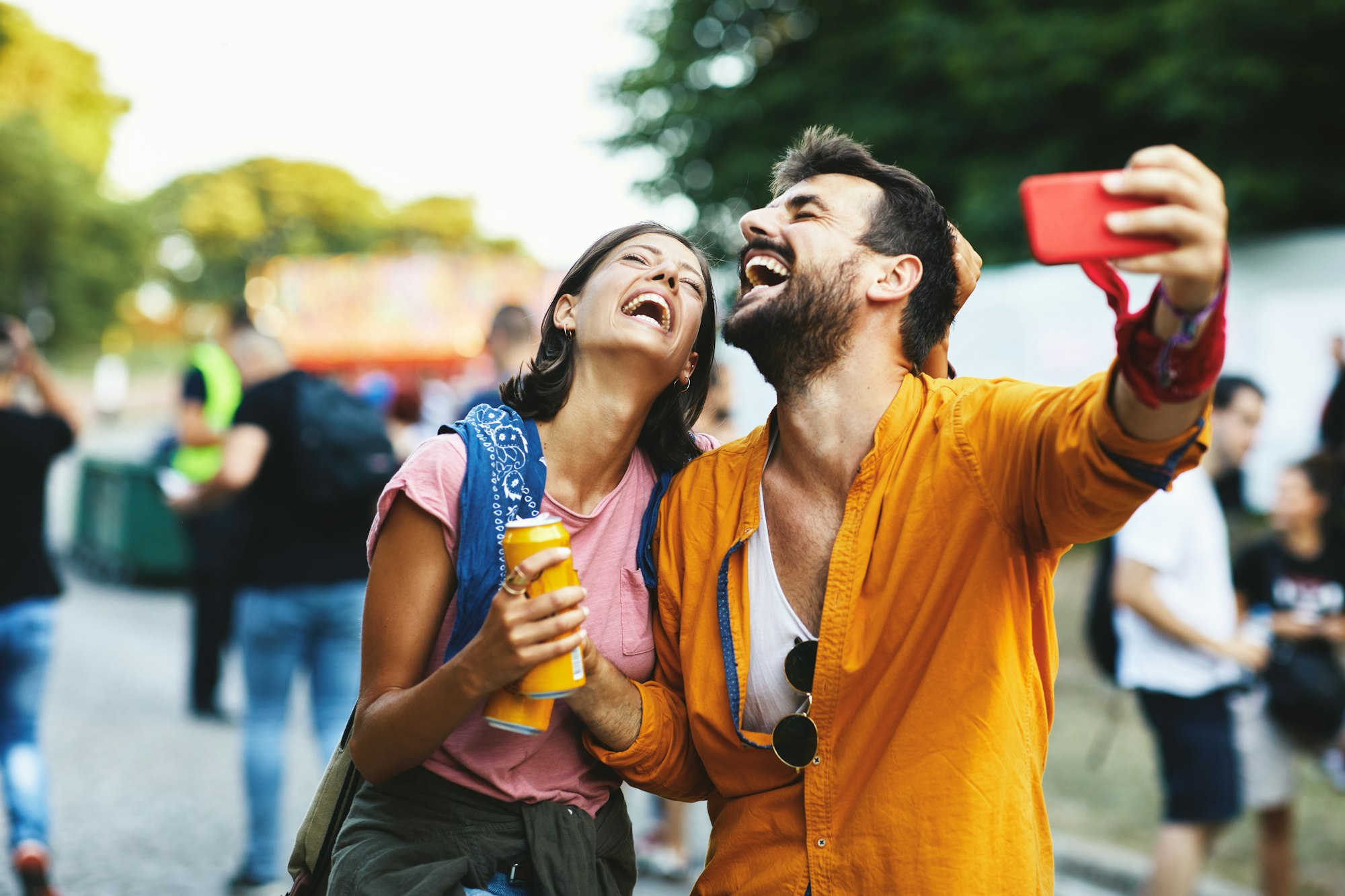 Young cheerful couple taking a selfie at a street music festival